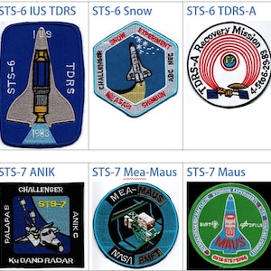 Op de afbeelding: Een collage van negen NASA-space shuttle-missie patches. Elke patch heeft een ander ontwerp, inclusief de namen van de missies, de space shuttle Challenger en de namen van de astronauten. De patches zijn allemaal in een blauw, wit en rood kleurenschema.