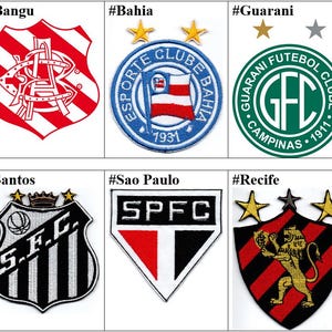 以下が含まれることがあります： ブラジルのサッカーチームのロゴが刺繍された10個のパッチのコラージュ。パッチは2行5列に配置されています。代表されているチームは、ASA、バンゴ、バイーア、グアラニー、イパチンガ、JEC、サントス、サンパウロ、レシフェなどです。