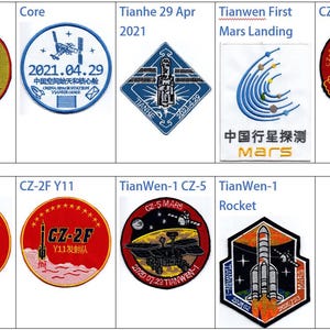 Op de afbeelding: Een verzameling van negen geborduurde patches met de logo's van het Chinese ruimtevaartprogramma. De patches zijn rond, vierkant en zeshoekig van vorm en hebben verschillende kleuren, waaronder rood, blauw, wit en zwart. De patches tonen raketten, ruimtevaartuigen en de Chinese vlag.