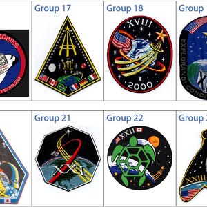 May include: A collection of eight NASA space shuttle mission patches. The patches are circular, square, and diamond shaped. The patches feature a variety of designs, including stars, planets, and the Earth. The patches are embroidered with colourful threads.