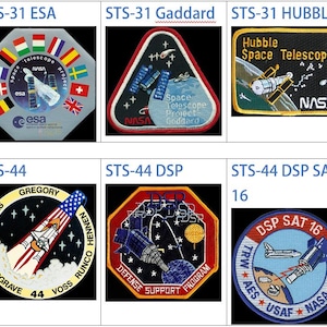 May include: A selection of space mission patches, including STS-31, STS-31 ESA, STS-31 Goddard, STS-31 Hubble, Soyuz TM-13, Soyuz TM-12, STS-44, and STS-44 DSP SAT 16. Each patch displays distinct designs and text.