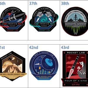 May include: A selection of Rocket Lab mission patches, each with distinct designs and text. The patches depict rockets, celestial bodies, and phrases such as "The Beat Goes On" and "Baby Comes Back." Colours include blue, black, red, and gold.