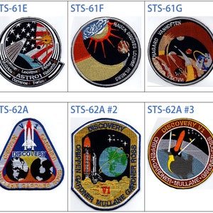 May include: A selection of ten embroidered patches, each with a unique design related to space missions. The patches display vibrant images of rockets, planets, and stars, along with mission names. Text includes "STS-61E", "STS-61F", "STS-61G", and "STS-62A".