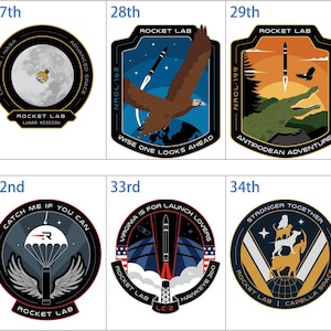 May include: A collection of Rocket Lab mission patches, each with unique designs and text. The patches feature rockets, eagles, owls, and other imagery, with phrases like "There and Back Again" and "Stronger Together."