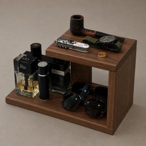 May include: A two-tiered wooden organizer stand holding a tobacco pipe, a multi-tool, a wristwatch with a green strap, a gold ring, two glass perfume bottles labeled Dior Homme and Yves Saint Laurent, and a pair of black sunglasses.