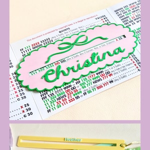 May include: A collection of Mahjong-themed gifts, including personalized name tags, decorative game pieces, and striped placemats. The image features a variety of colors, including pink, green, purple, and yellow. Text on the image reads "Gift ideas for Trendy Mahjong Lover."