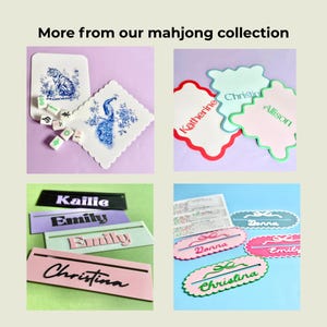 May include: A collection of mahjong-themed items. Includes decorative coasters with blue and white designs, name tags in various colors with names like "Katherine" and "Christina", and mahjong tiles. The text "More from our mahjong collection" is at the top.