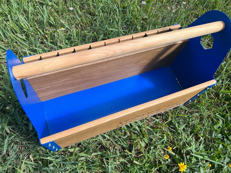 Pode incluir: Uma caixa de ferramentas de metal azul com uma al&ccedil;a de madeira e um inserto de madeira. A caixa de ferramentas tem um interior azul e um fundo de madeira.