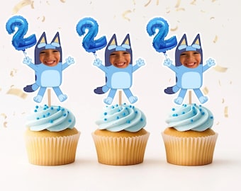 May include: Three cupcakes with light blue frosting and blue sprinkles. Each cupcake is topped with a Bluey-themed character holding a blue number 2 balloon. The background is white with gold confetti.