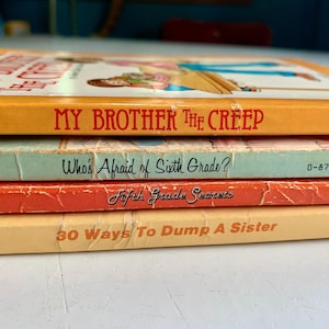 May include: A stack of four paperback books with colorful covers. The top book is yellow with the title "My Brother The Creep". The second book is light blue with the title "Who's Afraid of Sixth Grade?" The third book is orange with the title "Fifth Grade Secrets". The bottom book is yellow with the title "30 Ways To Dump A Sister".