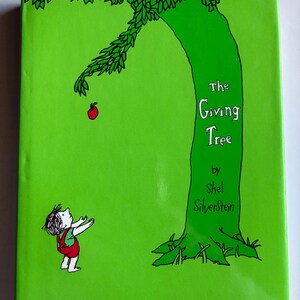 May include: A hardcover book titled "The Giving Tree" by Shel Silverstein. The cover is bright green with a large green tree and a small figure reaching for a red apple. The title is in white.