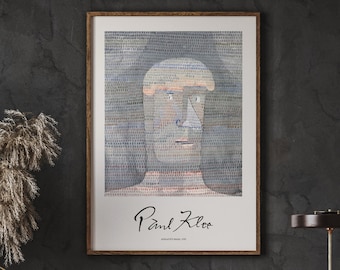 May include: A framed print of a watercolor painting of a person's face. The painting is in shades of blue, green, and pink. The artist's signature, "Paul Klee", is written in black ink at the bottom of the print.
