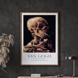 May include: A vintage poster featuring a painting of a skeleton smoking a cigarette. The painting is titled "Head of a Skeleton with a Burning Cigarette, 1885" by Vincent van Gogh. The poster is framed in a brown wood frame.