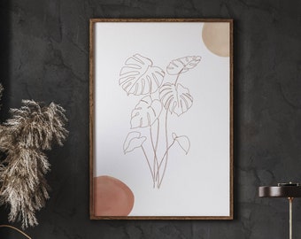 May include: A digital download of a line art print featuring a bouquet of tropical leaves with a brown and beige color scheme. The print is framed and displayed on a dark wall above a wooden console table.