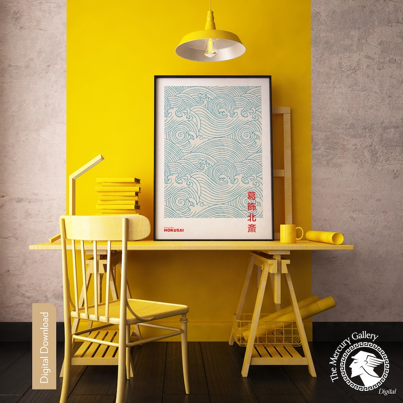 May include: A blue and white print of waves with Japanese text in red. The print is framed and hanging on a yellow wall above a wooden desk with a yellow chair and a yellow easel.