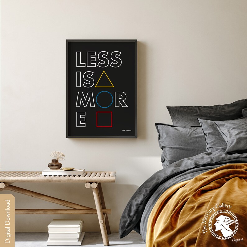 May include: A black and white typography print with the text "LESS IS MORE" in white with a yellow triangle, blue circle, and red square replacing the vowels. The print is framed in a black frame and hanging on a white wall.