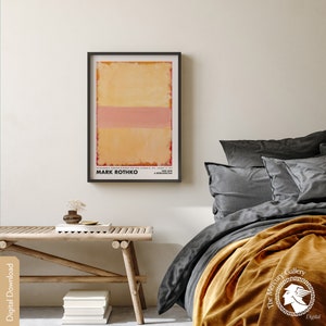 May include: A framed poster of a painting by Mark Rothko. The painting features three horizontal bands of color: a yellow band at the top, a pink band in the middle, and a red band at the bottom. The poster is titled "Mark Rothko" and includes the text "A Retrospective".