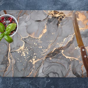 May include: A gray and gold marble-patterned cutting board with a small white bowl filled with red peppercorns and fresh basil leaves. A silver knife with a wooden handle is placed on the board.