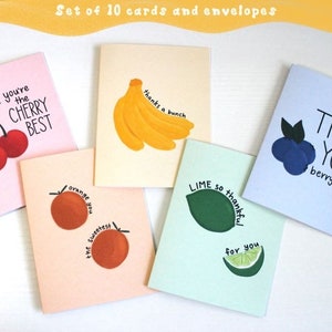 May include: A set of ten greeting cards and envelopes. Each card features a different fruit illustration, including cherries, bananas, oranges, blueberries, and limes, with accompanying text such as "You're the Cherry Best" and "Thank You berry much."