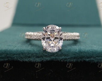 May include: A silver engagement ring with a large, round, clear diamond in the center. The ring is set with smaller diamonds around the band.