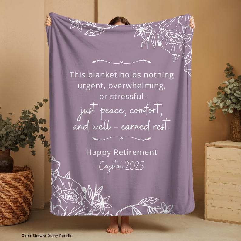 Peut inclure: Une couverture lavande avec des motifs floraux blancs et du texte. Le texte dit : &laquo; Ce plaid ne contient rien d'urgent, de bouleversant ou de stressant - juste la paix, le confort et le repos bien m&eacute;rit&eacute;. Bonne retraite Crystal 2025. &raquo;