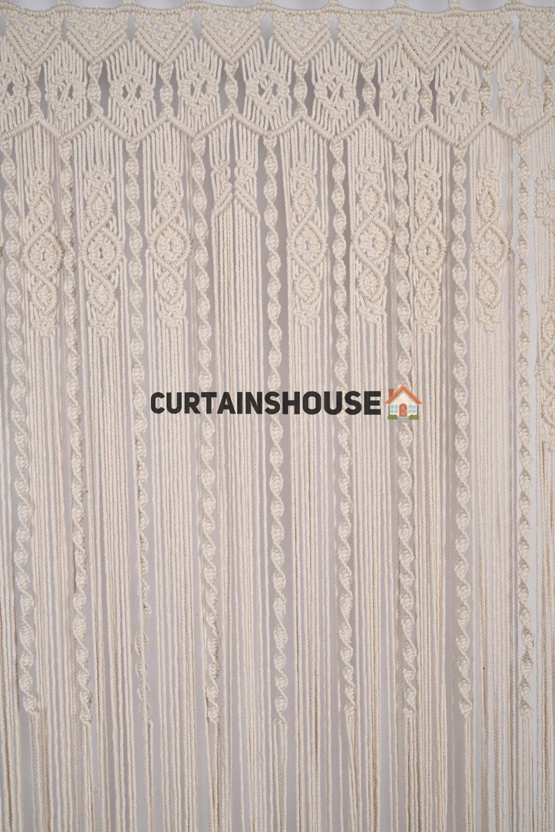 K&ouml;nnte beinhalten: Ein wei&szlig;er Makramee-Vorhang mit geometrischem Muster. Der Vorhang ist aus Baumwollschnur gefertigt und hat einen Fransen unten. Der Text "CURTAINSHOUUSE" ist in der Mitte des Bildes sichtbar.