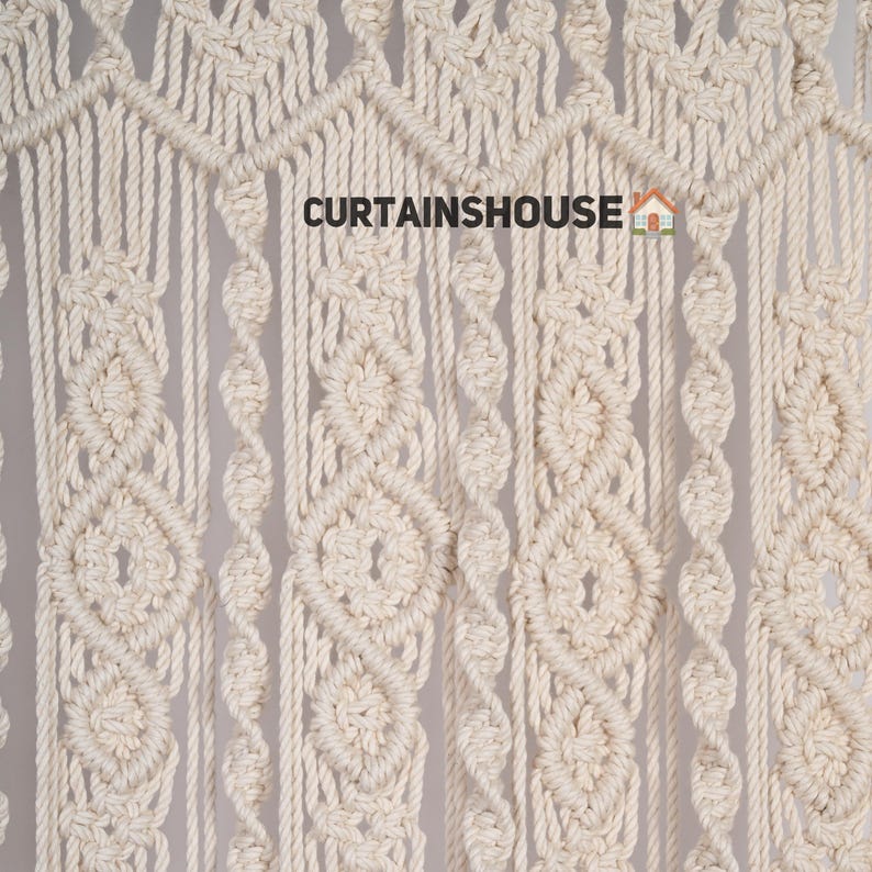 K&ouml;nnte beinhalten: Nahaufnahme einer Makramee-Wandbeh&auml;nge aus nat&uuml;rlichem Baumwollseil. Die Beh&auml;nge weist ein sich wiederholendes Muster aus Diamanten und Kreisen auf. Der Text "CURTAINS HOUSE" ist im Bild sichtbar.
