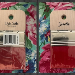 May include: Two paint brushes with wooden handles and red bristles. The brush on the left has a label that says "Dixie Belle Paint Company" and "Scarlet Brush". The brush on the right has a label that says "Scarlet" and "70".