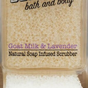 May include: A white and beige bath and body scrubby with the text "SCRUBBY bath and body" and "Goat Milk & Lavender Natural Soap Infused Scrubber". The scrubby is in a clear plastic container with a white lid. A watercolor illustration of a lavender flower bouquet is in the foreground.