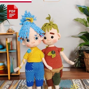 May include: Crochet pattern for two amigurumi dolls. The dolls are dressed in colorful clothing. The girl doll has blue hair and is wearing a yellow shirt and blue jeans. The boy doll has green hair and is wearing a red shirt and brown pants. The pattern is available as a PDF download.