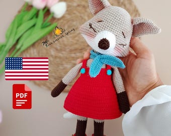 Puede incluir: Muñeca de zorro de ganchillo hecha a mano con un vestido rojo con botones azules, una bufanda azul y botas rojas. El zorro tiene los ojos cerrados y un hocico blanco. La muñeca se sostiene en una mano. Incluye el texto "Four seasons spring".