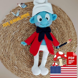 Puede incluir: Muñeco de los Pitufos hecho a mano con ganchillo, con gorro blanco, chaqueta roja y pantalones blancos. El muñeco sostiene un pincel y tiene la cara y las orejas azules. El texto "FOUR SEASONS SPRING" es visible. El muñeco está sobre una estera tejida.