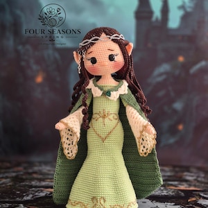 May include: A crocheted doll with long brown hair, pointed ears, and a silver headpiece. The doll wears a light green dress with gold embroidery, a dark green cape, and white lace-trimmed sleeves. The text FOUR SEASONS SPRING is visible above.