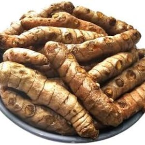 May include: A close-up of a pile of turmeric root fingers, with a light brown colour and a rough texture.