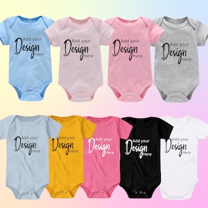 May include: Ten baby onesies in a variety of colours, including light blue, pink, yellow, black, and white. Each onesie has short sleeves and a popper fastening. The onesies are blank and feature the text "Add your Design Here" in black.