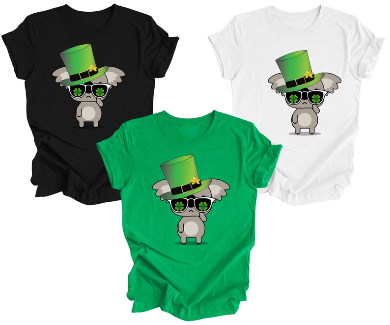 May include: Three t-shirts featuring a cartoon koala wearing a green leprechaun hat and sunglasses. The shirts are black, white, and green.