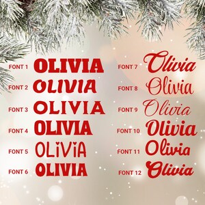 May include: A selection of the name "Olivia" in various red fonts. The fonts range from bold block letters to elegant cursive styles. The image is set against a soft, blurred background with a festive, wintery theme.