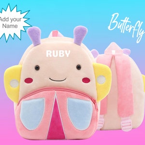 May include: Pink butterfly-shaped plush backpack with yellow wings, blue accents, and a zipped pocket. The backpack has a personalised name tag that says "RUBY".