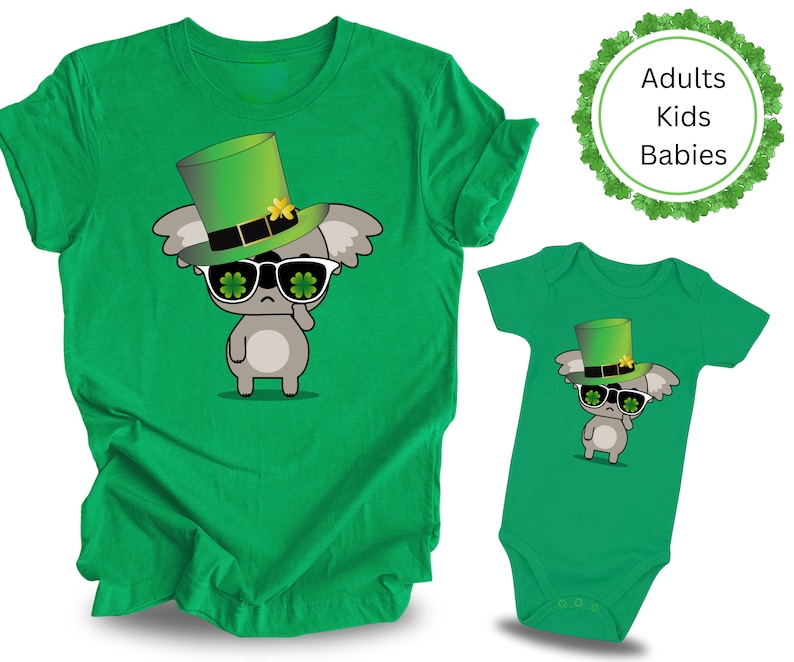 May include: Green t-shirt and bodysuit with a cartoon koala wearing a green leprechaun hat and sunglasses with shamrocks. The text "Adults Kids Babies" is on a green shamrock background.