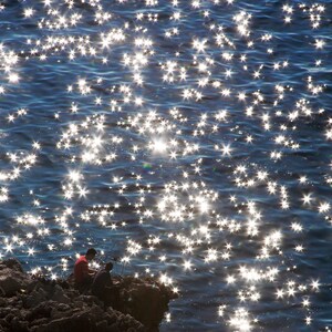 Zwei Leute beim Fischen entlang der Küste der Insel Capri, am Tyrrhenischen Meer