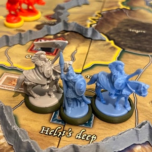 Puede incluir: Tres figuras de pl&aacute;stico en miniatura de guerreros montados en un tablero de juego. Las figuras est&aacute;n pintadas en tonos de azul y gris. El tablero tiene una superficie marr&oacute;n y gris con el texto "Helgi's deep" impreso en &eacute;l.