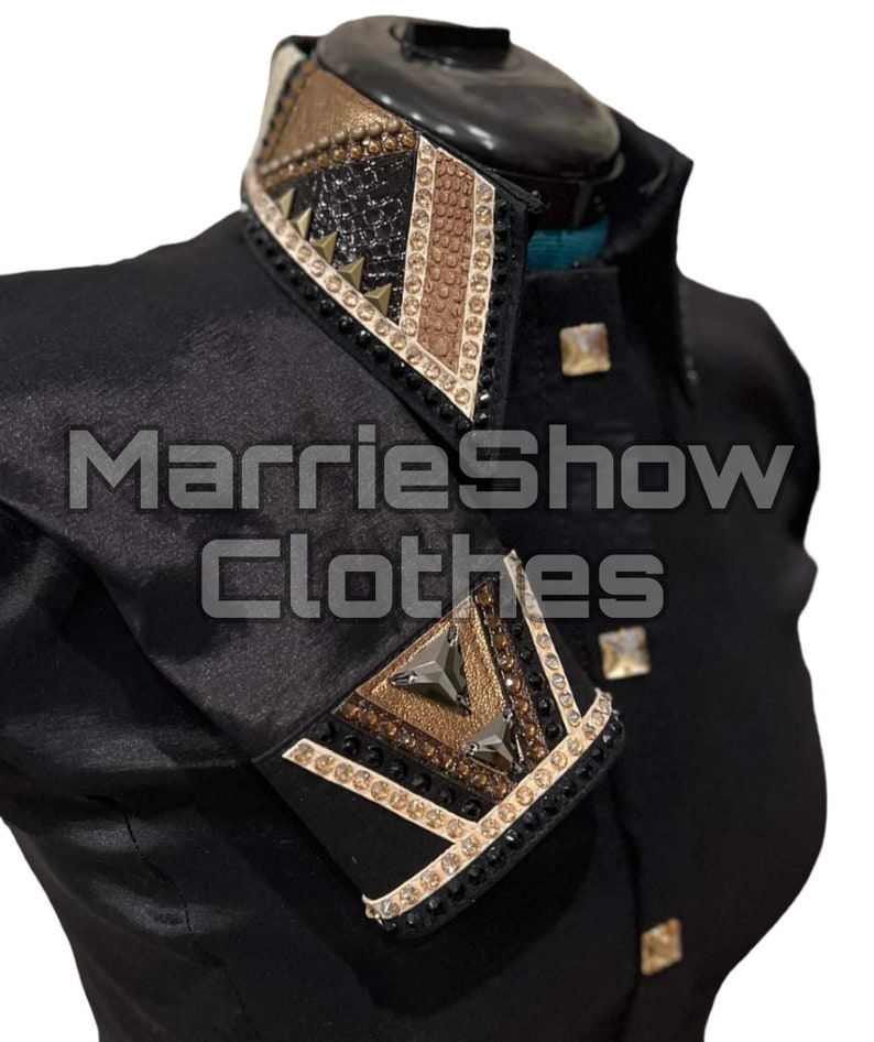 May include: Black show jacket with decorative collar and cuffs. The collar and cuffs feature a geometric design with gold, brown, and black accents, embellished with rhinestones and studs. The text "MarrieShow Clothes" is visible on the jacket.