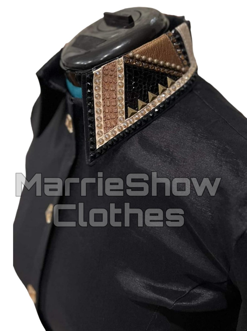May include: Black shirt with a decorative collar. The collar features a geometric design with gold, brown, and black accents, including rhinestones and studs. The text "MarrieShow Clothes" is visible.