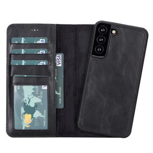 May include: Black leather wallet-style phone case with card slots and a separate phone holder. The wallet is open, showing multiple credit cards and a clear ID window. The phone case has a camera cutout.