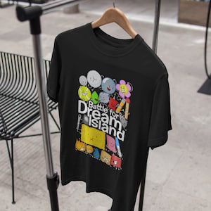 Pode incluir: Camiseta preta com um gráfico de personagens do programa "Battle for Dream Island". Os personagens são coloridos e têm expressões diferentes. O texto "Battle for Dream Island" está escrito em letras brancas.