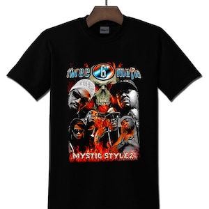 May include: Black t-shirt with a graphic design. The design includes the text "three 6 mafia" above a skull and images of people. The words "Mystic Stylez" are printed below the images in red.