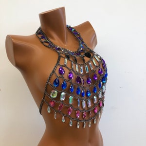K&ouml;nnte beinhalten: Ein silberner Ketten-K&ouml;rper-Schmuck mit tropfenf&ouml;rmigen Kristallen in den Farben Rosa, Blau und Lila.
