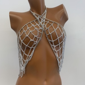 May include: Silver chainmail body jewelry with a criss-cross design and dangling chains.