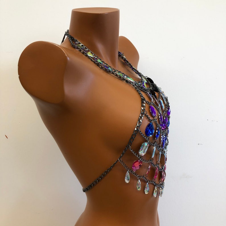 K&ouml;nnte beinhalten: Ein silberner Ketten-K&ouml;rper-Schmuck mit schillernden, rosa, blauen und violetten tropfenf&ouml;rmigen Kristallen.