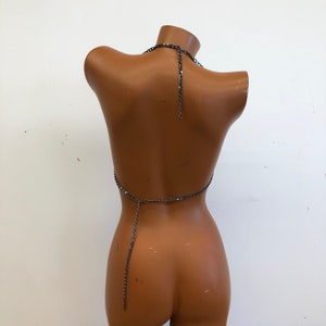 K&ouml;nnte beinhalten: Ein silbernes Ketten-Halter-Top mit einer langen Kette, die am R&uuml;cken herunterh&auml;ngt.